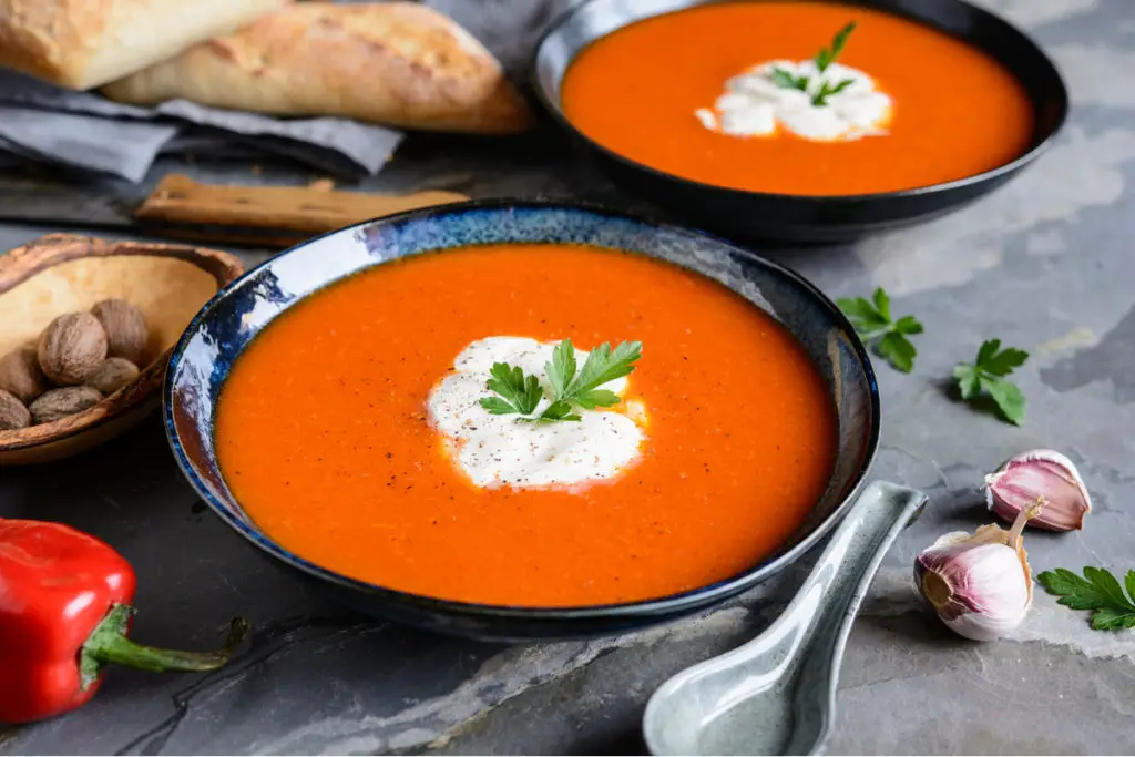 Tomato soup in a black bowl.