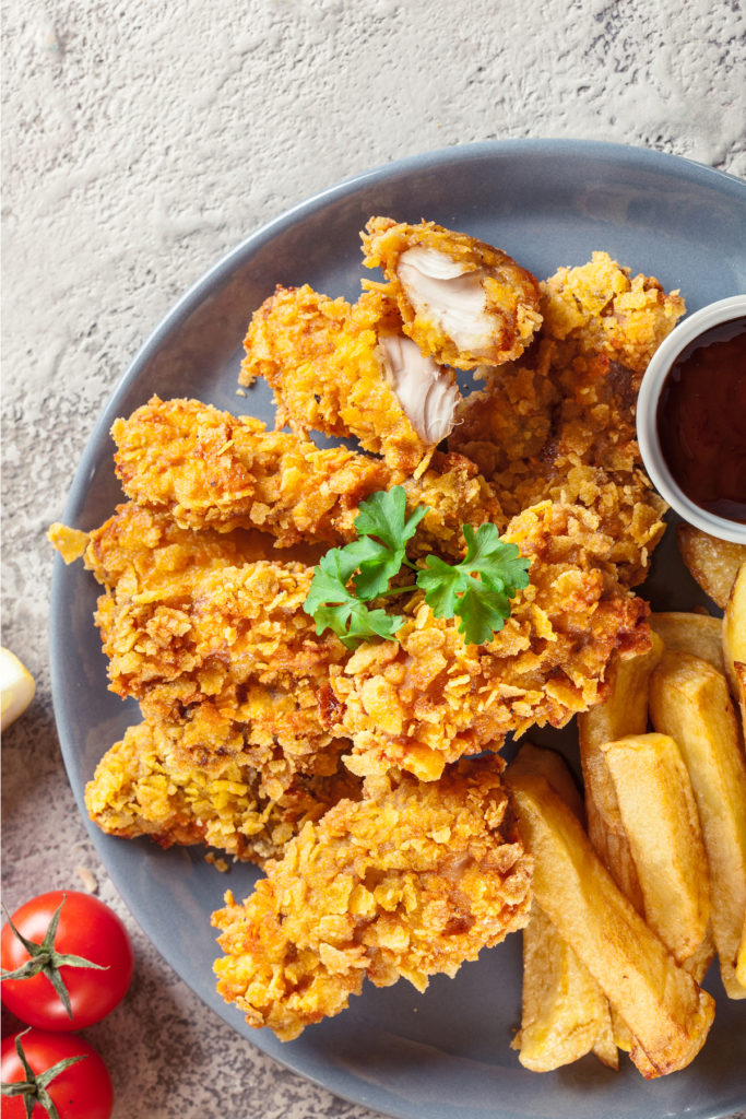 Fried chicken and french fries on a gray plate.