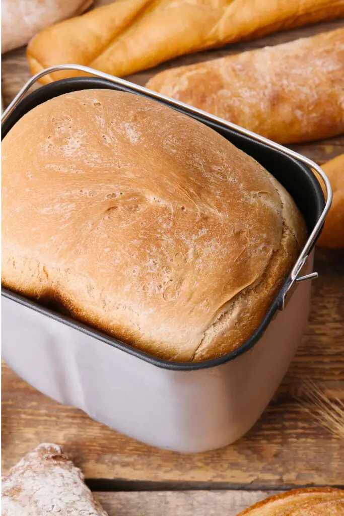 A fresh made loaf of bread in a bread machine basket.