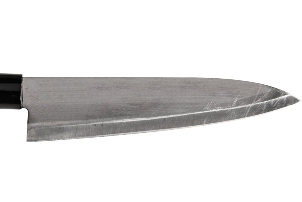 A Gyutou Knife on a white surface.