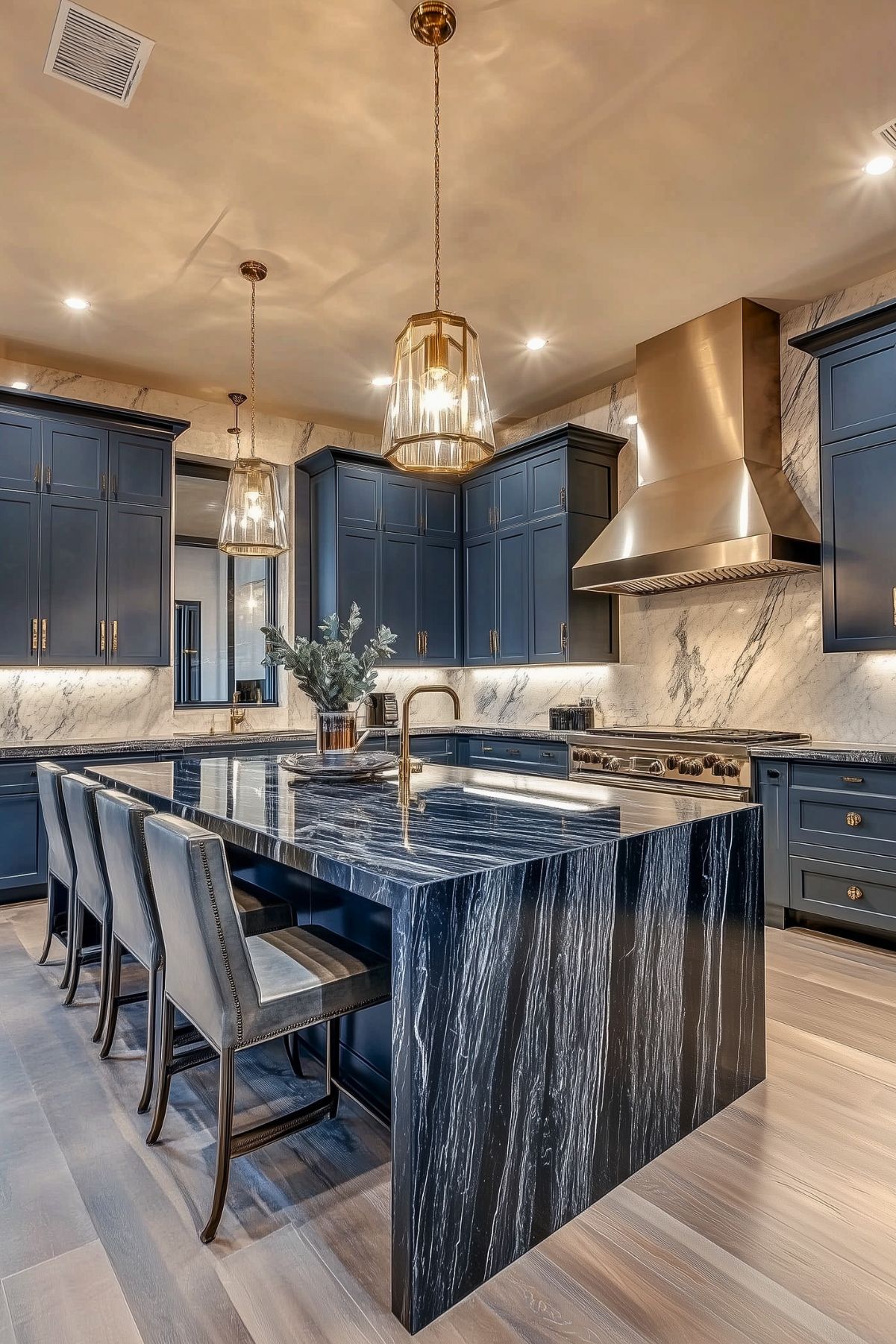 Luxurious navy blue kitchen with dramatic dark marble island, brass accents, stainless steel range hood, and pendant lighting; sleek seating and marble backsplash create a sophisticated ambiance.