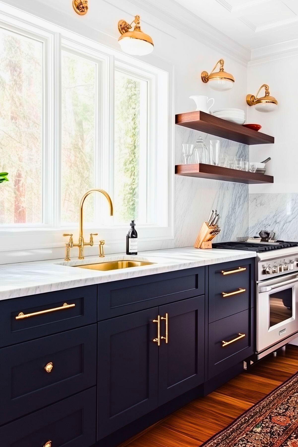 Navy blue kitchen with marble countertops, brass hardware, and open wooden shelves; features brass faucet, wall sconces, and a classic rug, creating a warm and inviting space.