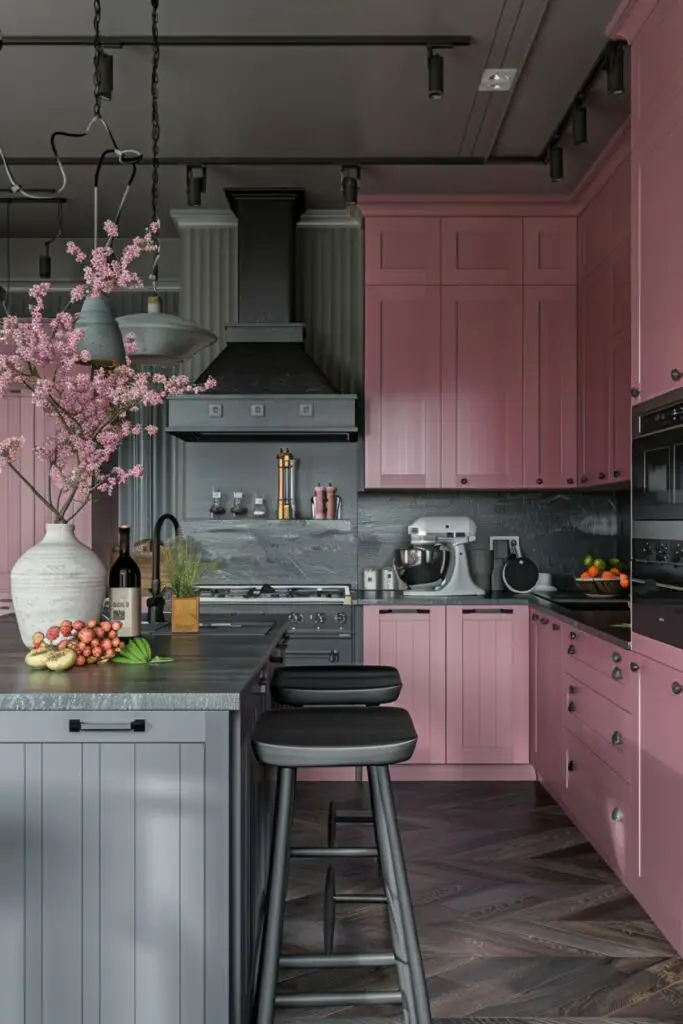 A chic and contemporary kitchen that harmoniously blends charcoal and pink tones. The cabinetry features soft pink fronts, providing a warm contrast to the charcoal countertops and island. The island itself is a sleek charcoal with matching barstools that have comfortable black cushions. Above the island, industrial-style pendant lights with exposed wiring add a modern, edgy touch. The backsplash and range hood are in a deep charcoal, enhancing the sophisticated atmosphere.