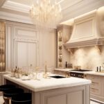 Luxurious kitchen with a grand chandelier, light-colored cabinetry, and a marble countertop island. The elegant design includes detailed moldings, gold accents, and sophisticated decor, creating a warm and inviting space perfect for entertaining.