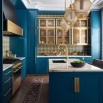 Peacock blue and gold kitchen with gold lighting.