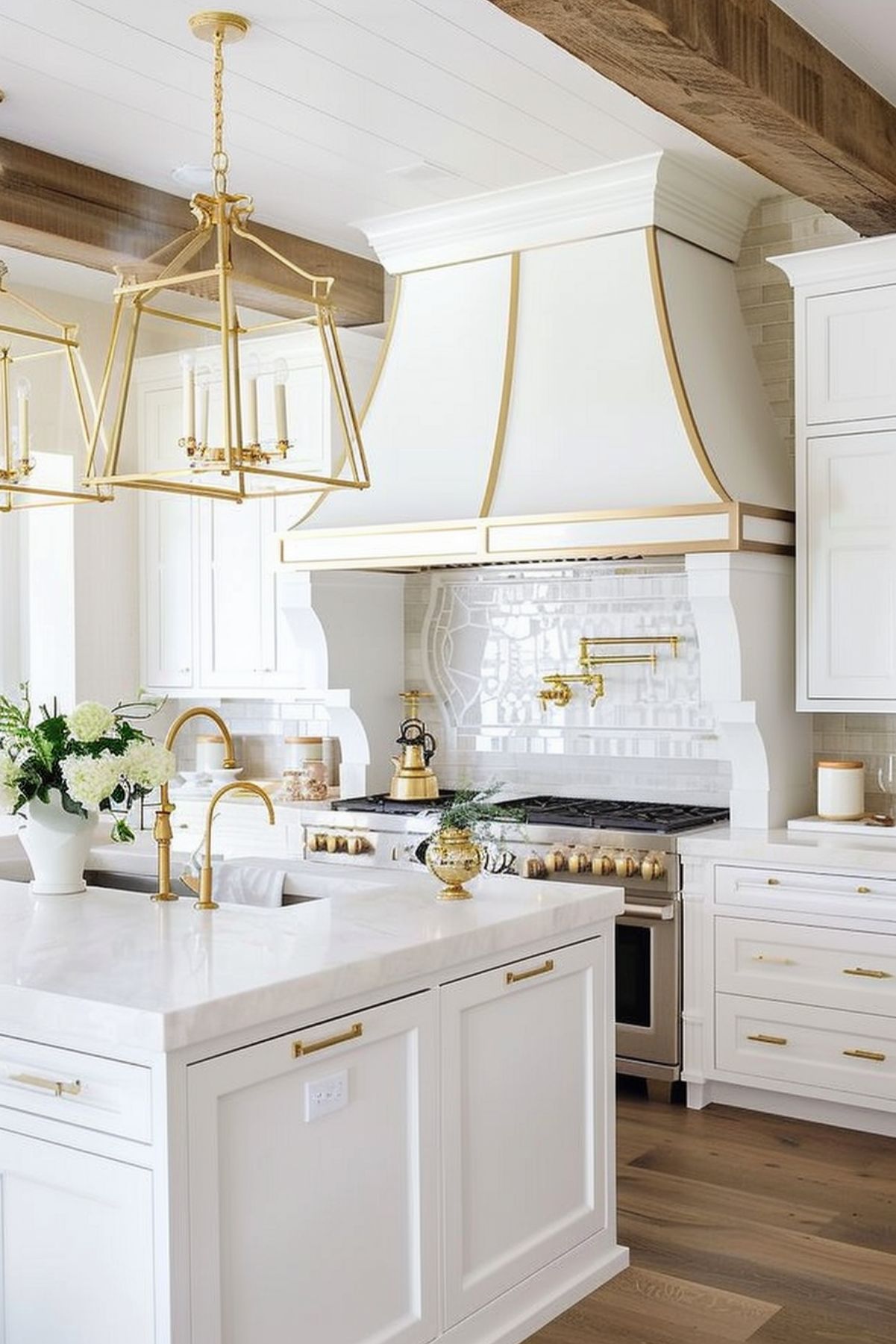 A sophisticated white kitchen accentuated with gold fixtures and lighting. This luxurious space features elegant cabinetry, a grand range hood with gold trim, and a marble countertop. The design is highlighted by gold geometric chandeliers, a matching faucet, and decorative elements that enrich the overall aesthetic. Exposed wooden beams on the ceiling add a touch of rustic charm to this refined kitchen.