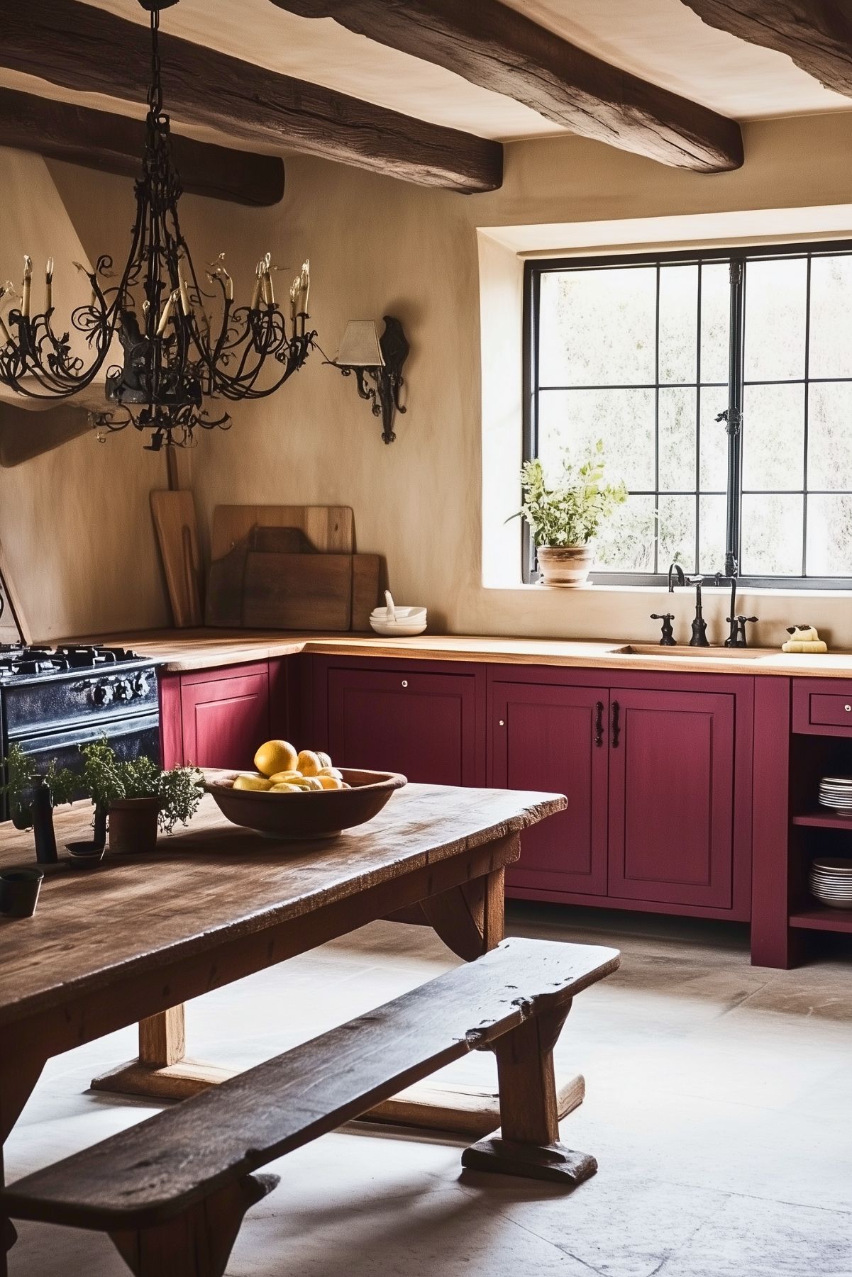 Rustic kitchen featuring burgundy cabinets, butcher block countertops, a wooden dining table with a bench, a wrought iron chandelier, exposed wooden ceiling beams, and a black-framed window.