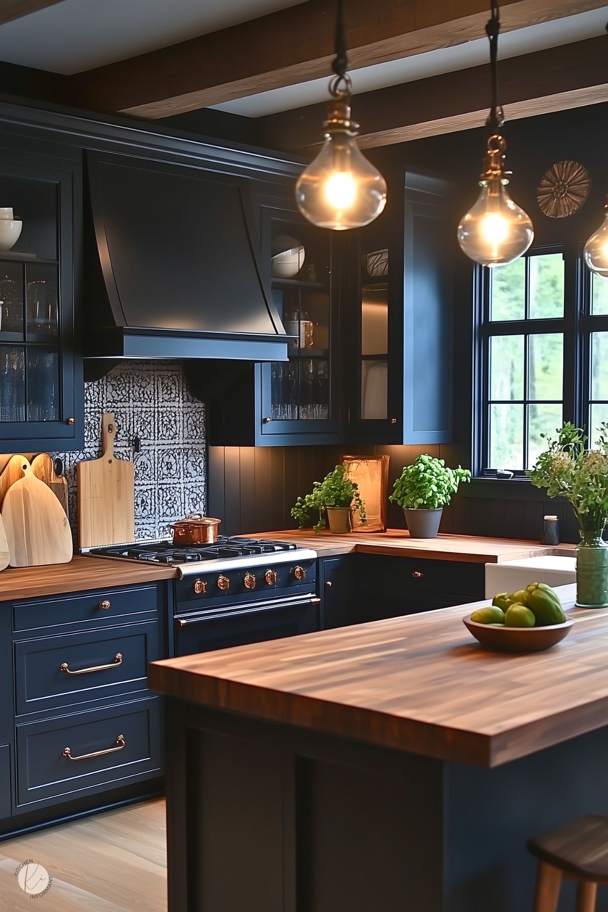 A moody kitchen design featuring navy blue cabinetry with brass hardware, butcher block countertops, and open shelving. The backsplash showcases a patterned tile, and a matte black range hood adds contrast. Wooden cutting boards, potted herbs, and a bowl of green apples add warmth and freshness. Pendant lights with exposed bulbs hang from the ceiling, enhancing the cozy ambiance.