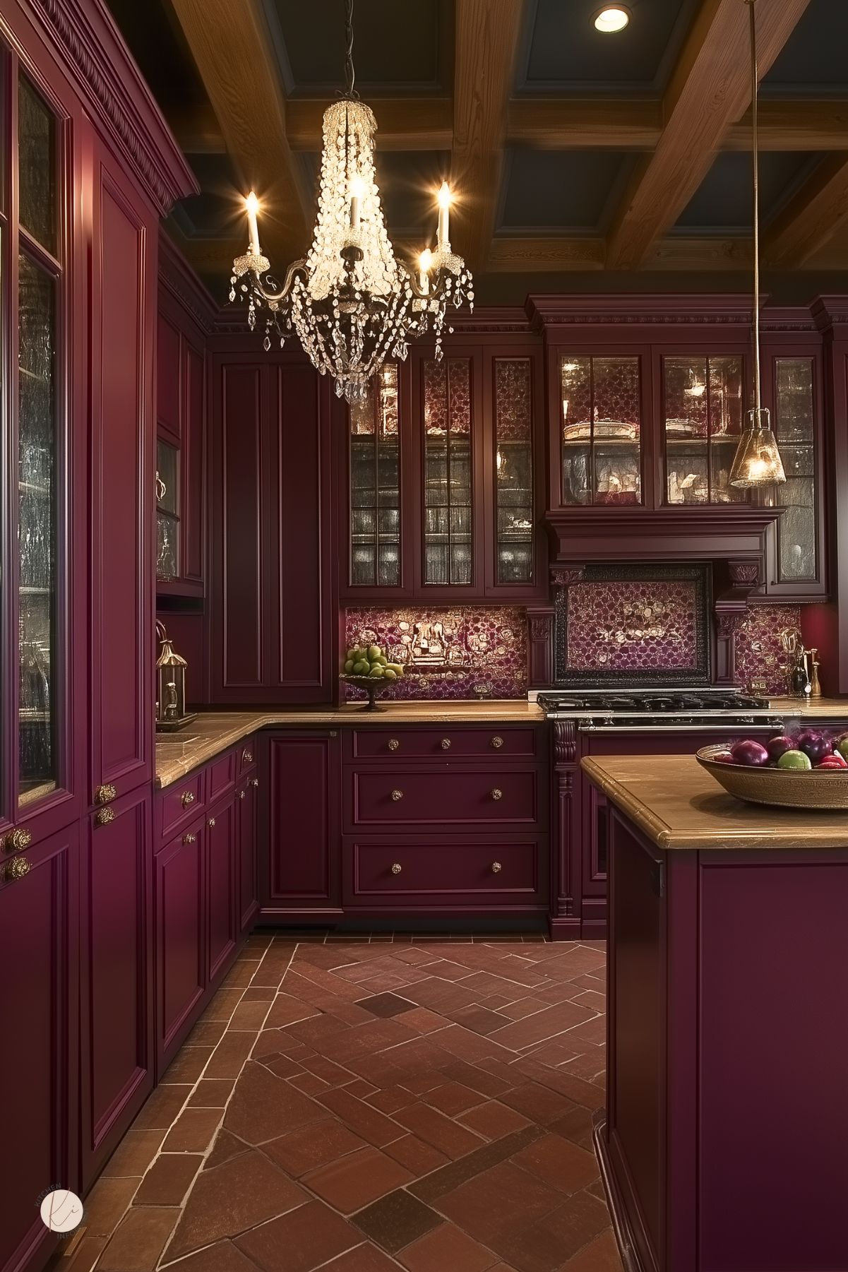 Elegant traditional kitchen with deep burgundy cabinetry, warm wood countertops, glass-front cabinets, a detailed burgundy and gold mosaic backsplash, a brick tile floor, and a sparkling crystal chandelier, creating a luxurious and inviting space.