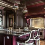 Elegant kitchen with rich burgundy cabinetry, a burgundy coffered ceiling, dark stone countertops, ornate upholstered barstools with white wood frames, and metallic pendant lights, blending luxurious traditional design with dramatic color contrasts.
