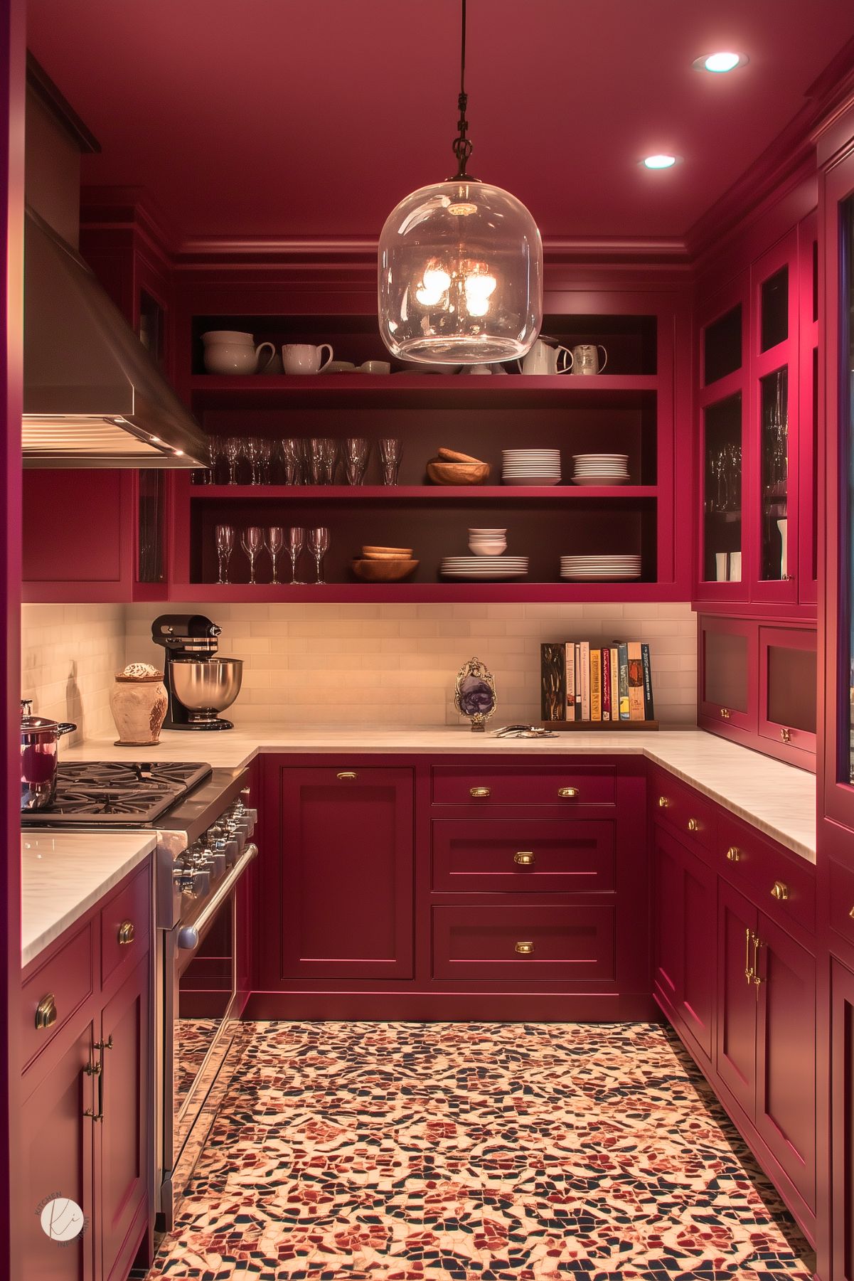 Cozy traditional kitchen with deep burgundy cabinetry, open shelving displaying dishes and glassware, a white subway tile backsplash, marble countertops, a mosaic tile floor, and a glass pendant light, creating a warm and inviting space.
