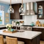 Coastal kitchen with chocolate brown cabinets, baby blue walls, and a white marble island with sink. Two woven bar stools and glass pendant lights add warmth, while a stainless steel range hood, white subway tile backsplash, turquoise kettle, and ocean-view window create a bright beach-inspired kitchen design.