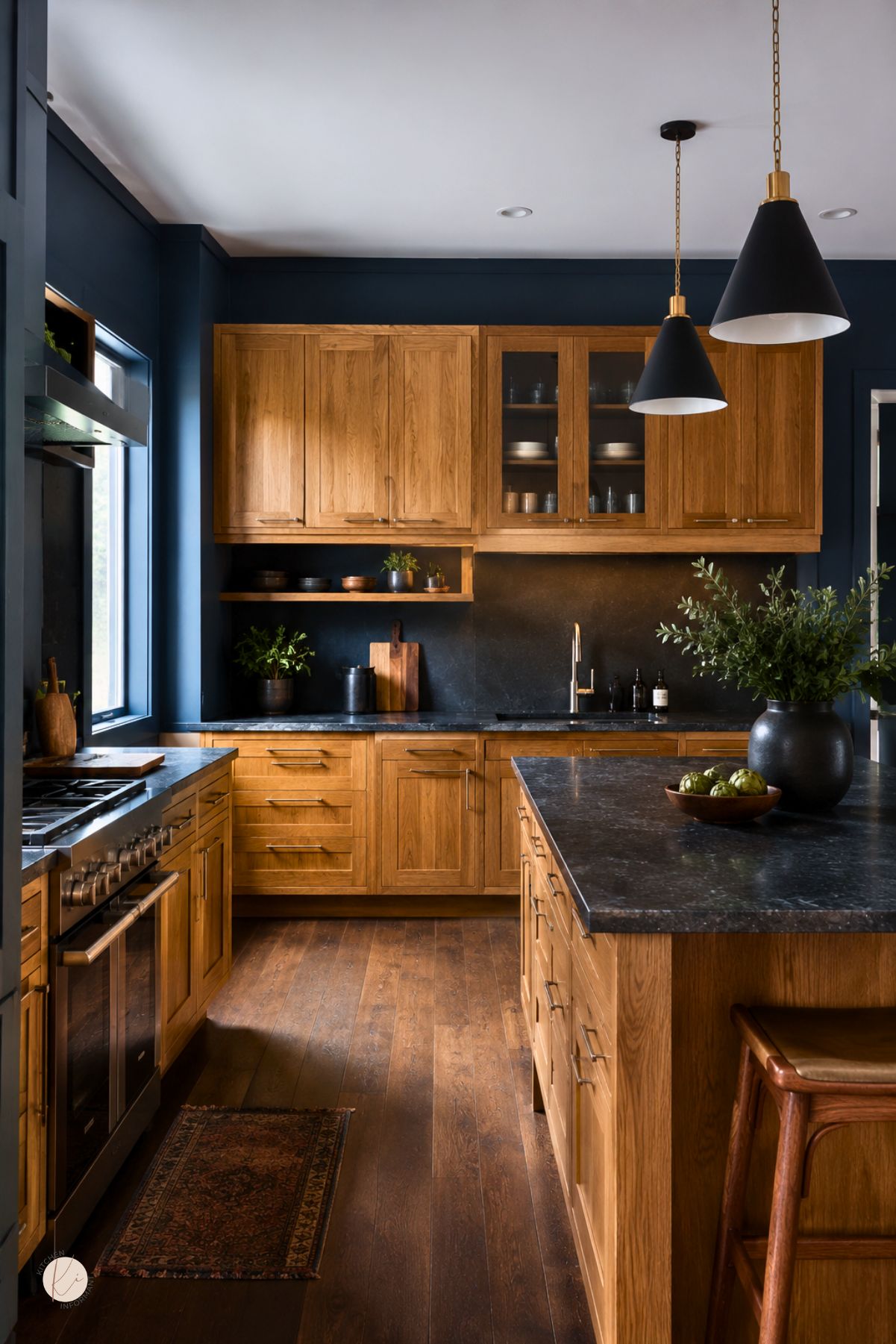 Moody blue kitchen with oak cabinets, black stone countertops, wood flooring, black pendant lights, a large island, stainless range, dark backsplash, and warm natural wood accents.