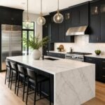 Modern kitchen with black cabinets, brass hardware, white marble countertops, and a waterfall island. Glass globe pendant lights, stainless steel appliances, black bar stools, marble backsplash, and warm wood floors create a sleek luxury kitchen design.